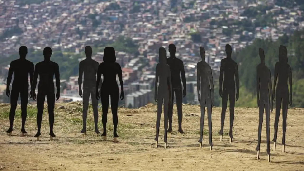 Siluetas de personas son utilizadas para conmemorar a las víctimas en La Escombrera, en la Comuna 13 de Medellín, donde continúan las labores de remoción de tierra. FOTO Manuel