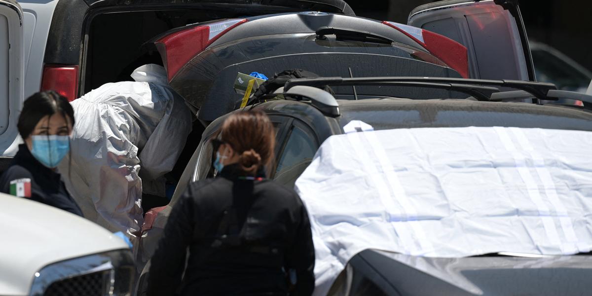 Los peritos forenses inspeccionaron una camioneta Toyota en la que supuestamente se encontró un cadáver en un estacionamiento en las inmedicaciones de un estadio en Tijuana.
