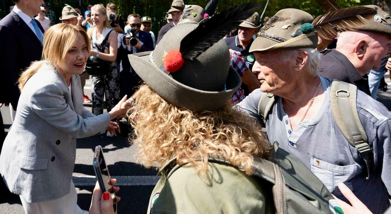 Meloni a sorpresa dagli alpini: orgoglio nazionale E Trump attacca ancora: «Italia, così non va bene» ​La premier stavolta non replica. Gelo con i Maga