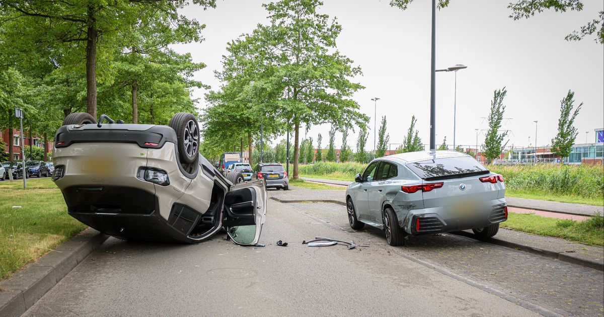 Auto botst tegen geparkeerde auto en slaat over de kop