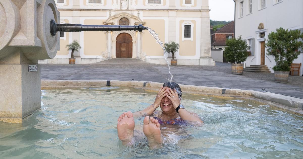 Une femme se rafraîchit dans une fontaine dans le canton de Bâle-Campagne [KEYSTONE - URS FLUEELER]