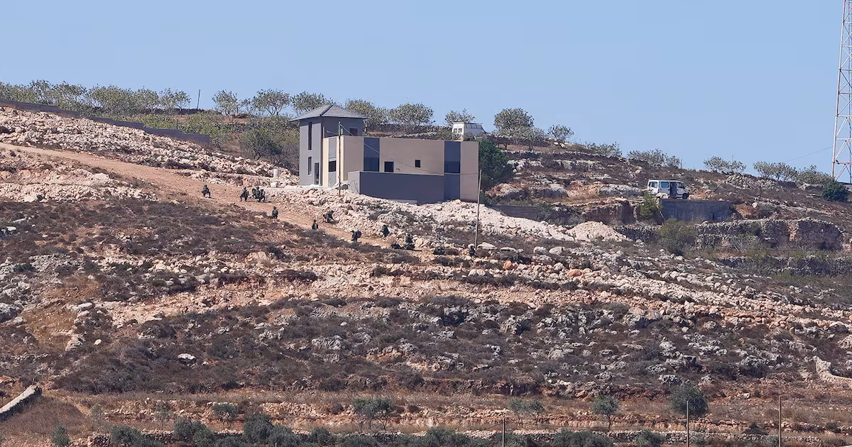 Israeli soldiers near Palestinian house besieged by settlers in Qusra village