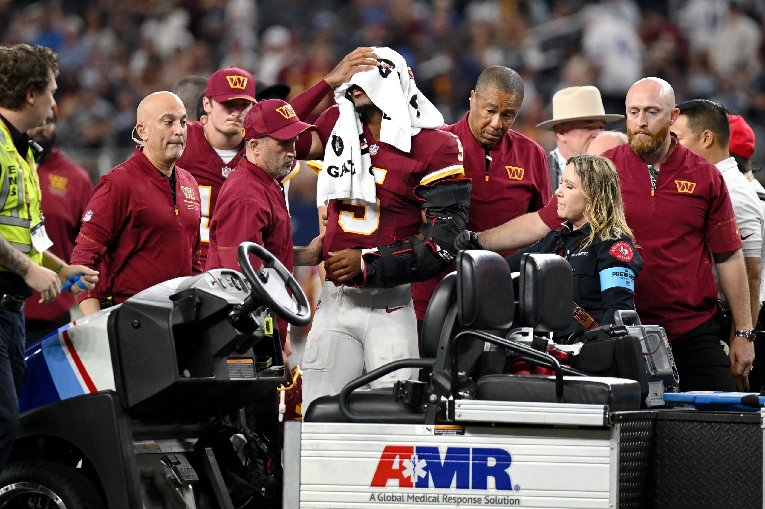 Commanders' Jayden Daniels carted off field after injuring left elbow during Dallas Cowboy game.