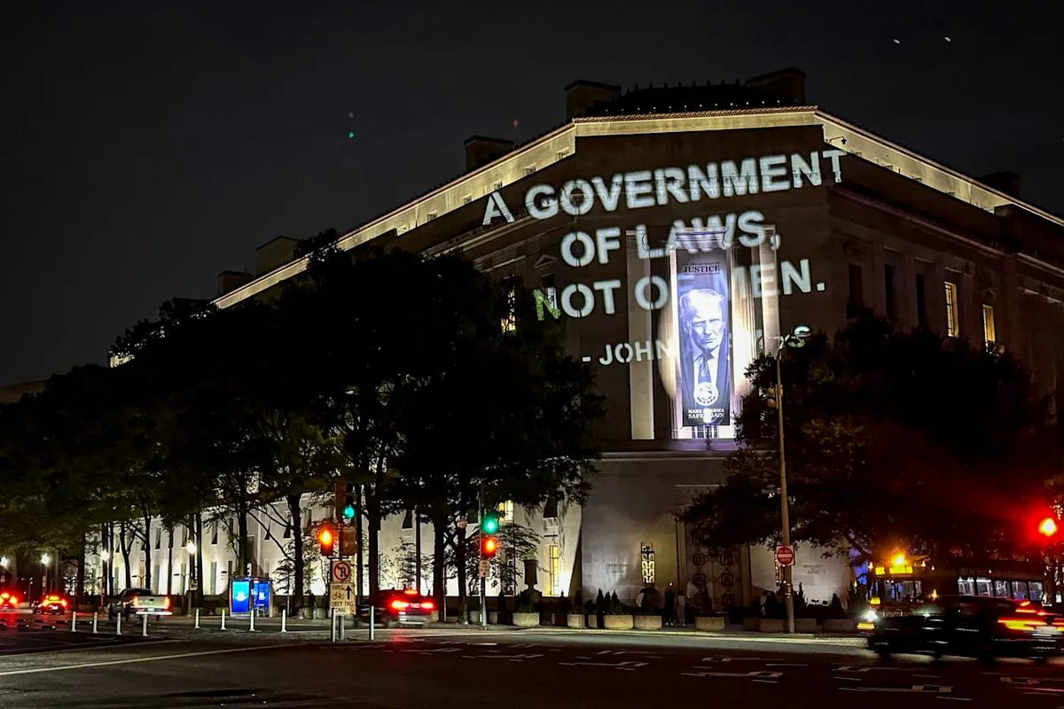 John Adams quote projected on DOJ building in protest of $1.8B fund